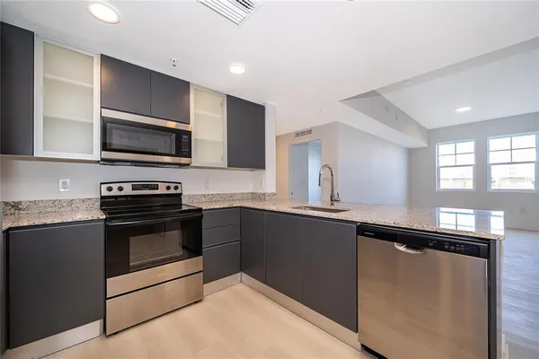 a kitchen with granite countertop a sink and steel appliances