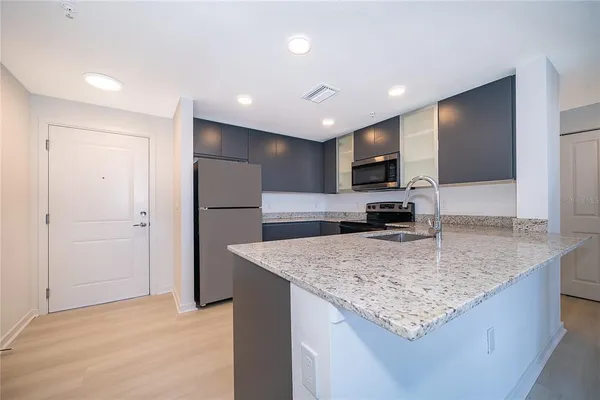 a kitchen with stainless steel appliances granite countertop granite counter tops and a refrigerator