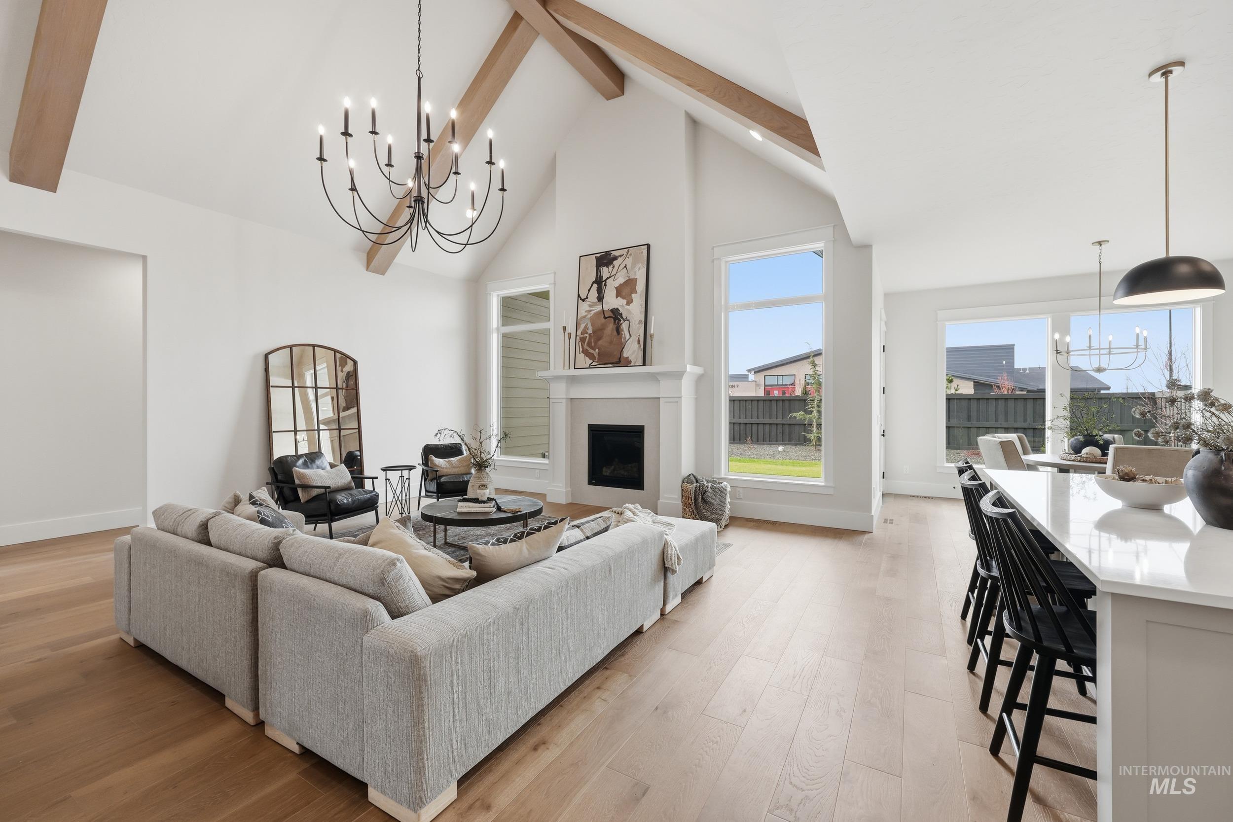 6513 South Utmost Way Meridian, ID 83642 - Photo 2 of 47 Living room with a chandelier, a fireplace, high vaulted ceiling, beam ceiling, and light wood-style floors