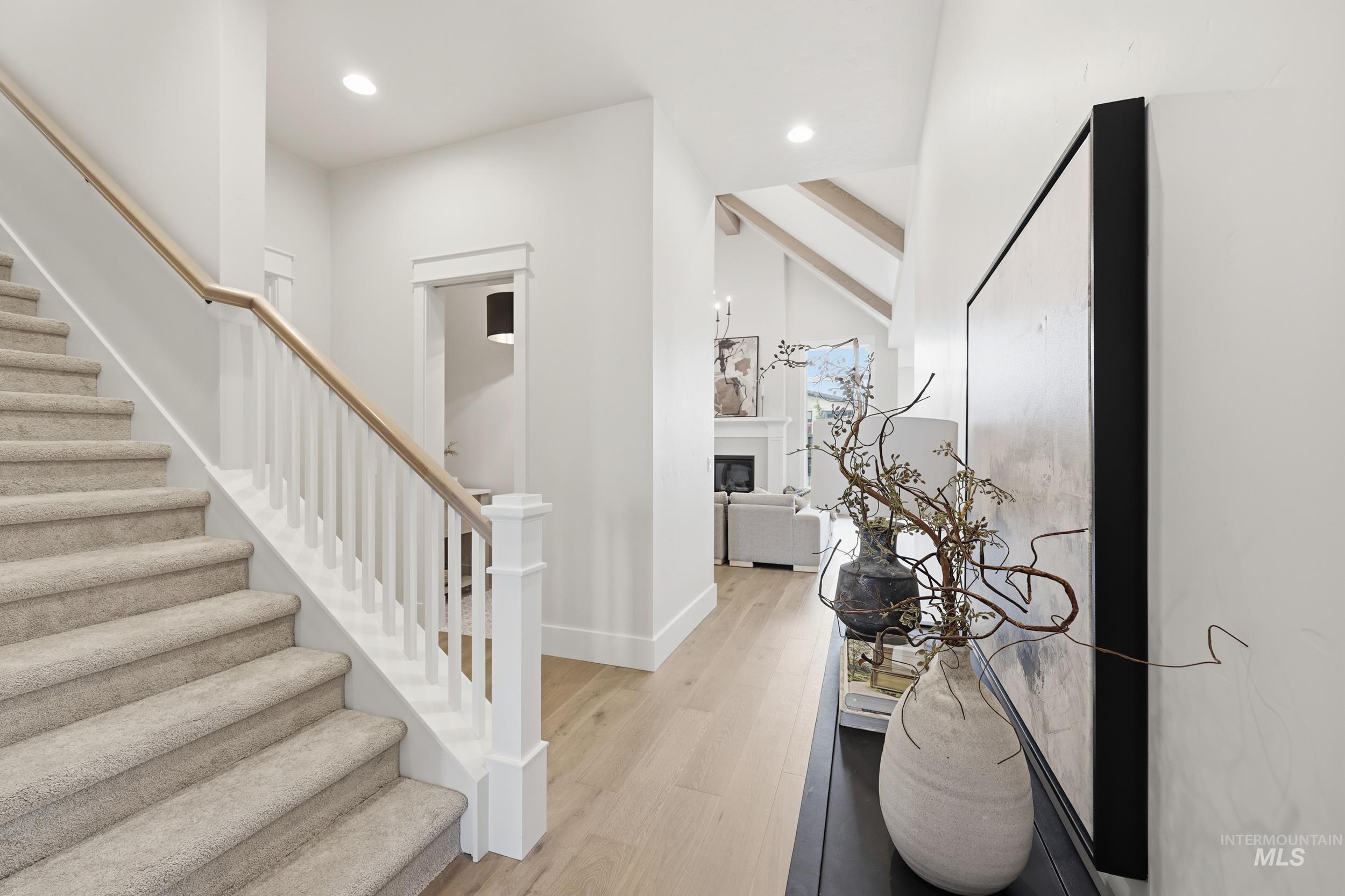 6513 South Utmost Way Meridian, ID 83642 - Photo 27 of 47 Foyer with stairs, light wood-type flooring, recessed lighting, and a glass covered fireplace