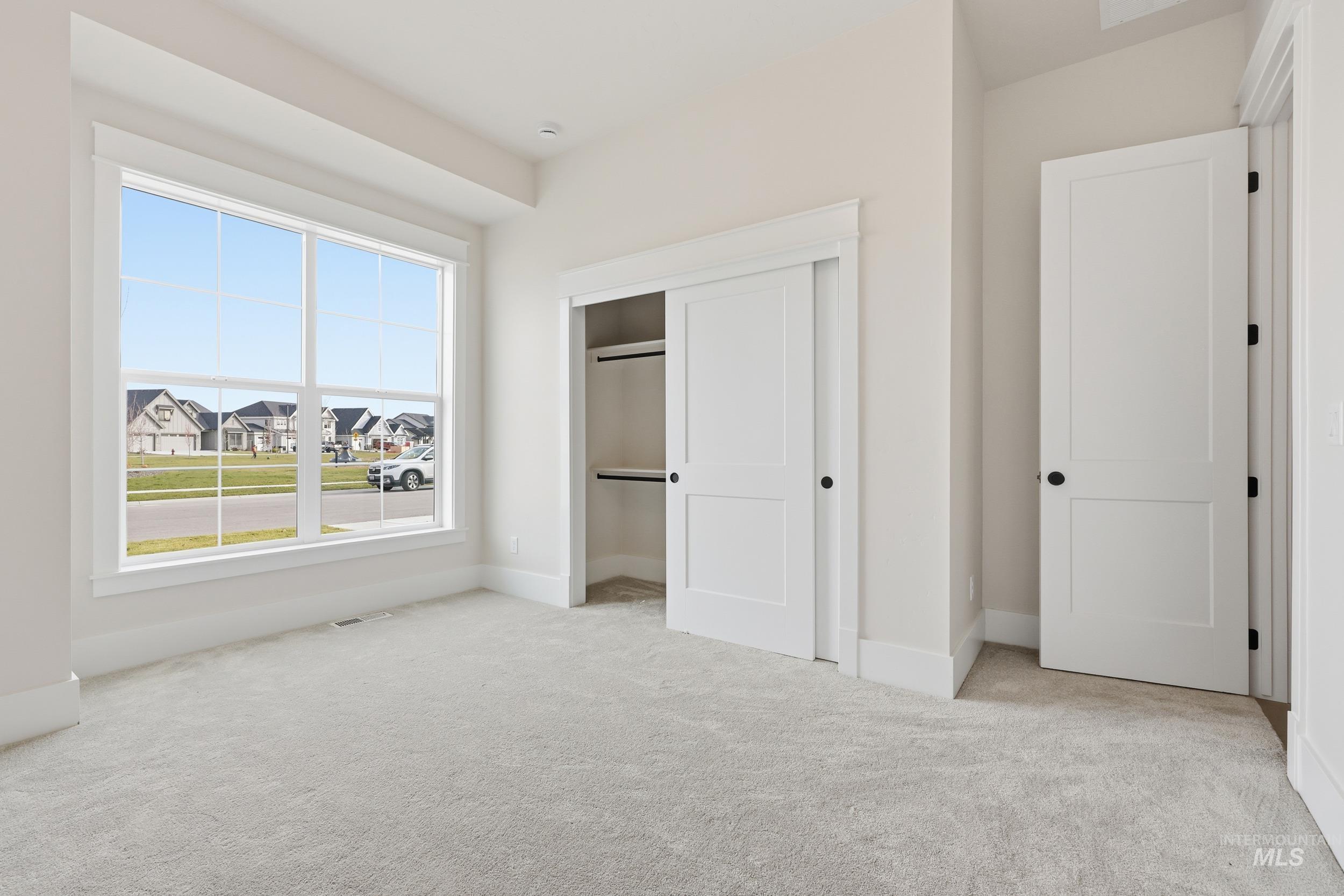 6513 South Utmost Way Meridian, ID 83642 - Photo 29 of 47 Unfurnished bedroom with a closet, light carpet, and a residential view