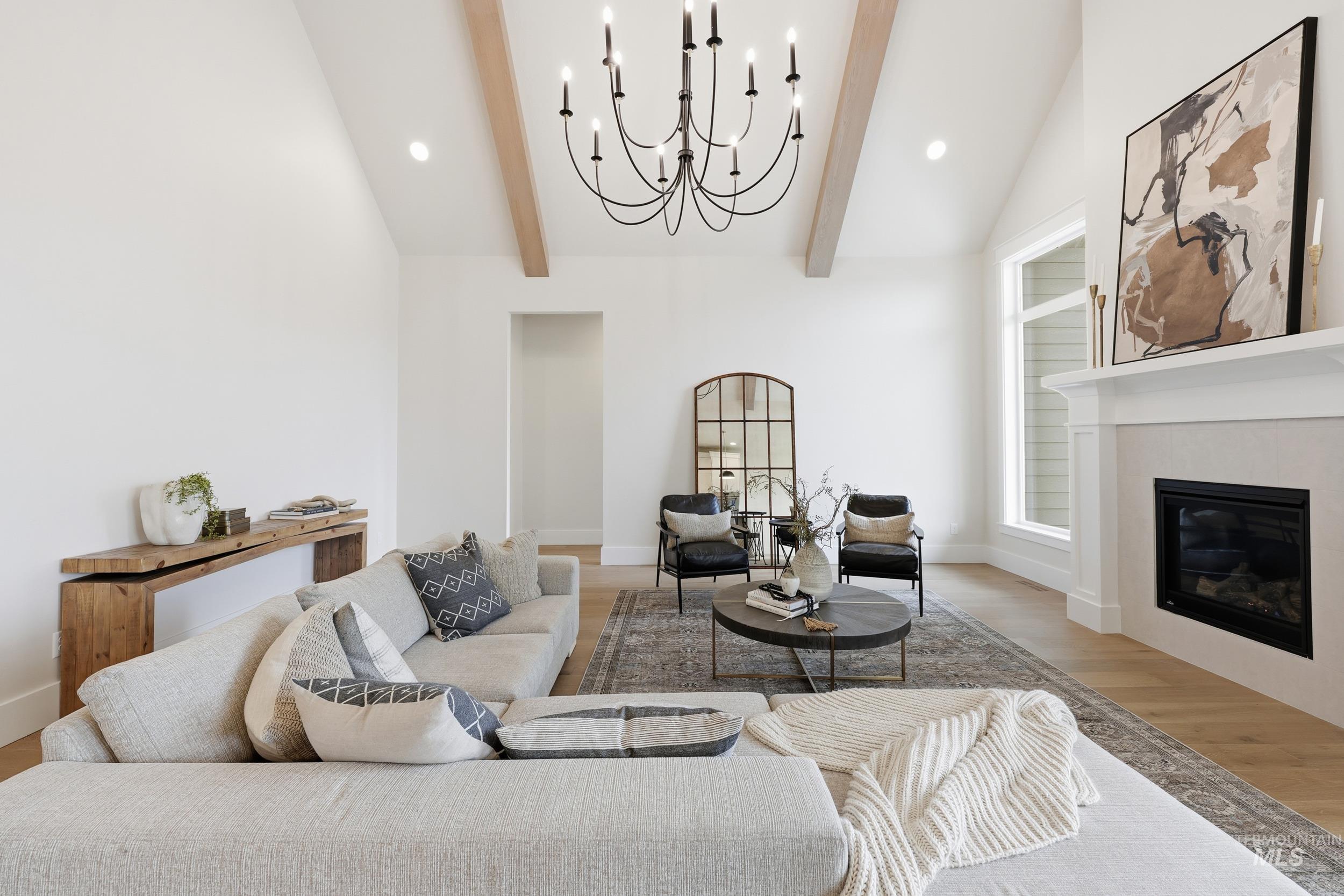 6513 South Utmost Way Meridian, ID 83642 - Photo 5 of 47 Living room with recessed lighting, a chandelier, a glass covered fireplace, and wood finished floors