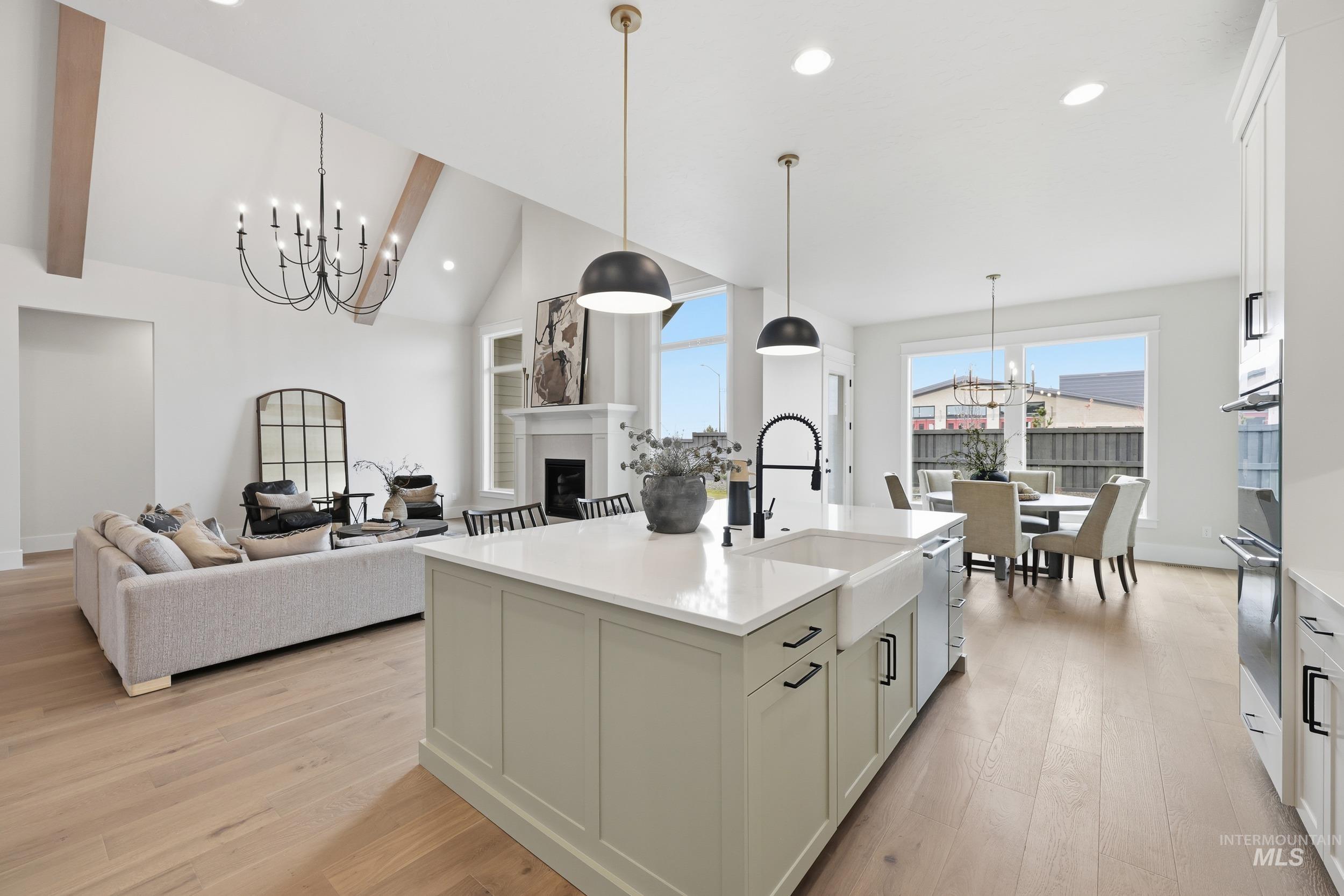 6513 South Utmost Way Meridian, ID 83642 - Photo 8 of 47 Kitchen with a chandelier, hanging light fixtures, a fireplace, recessed lighting, and an island with sink