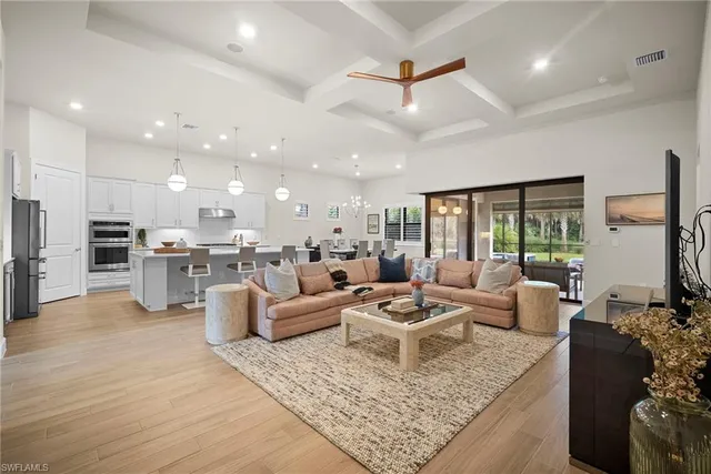 a living room with furniture kitchen view and a large window