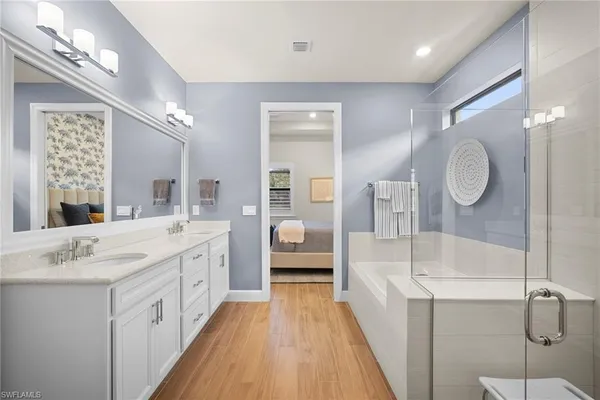 a spacious en suite bathroom with a double vanity sink and a mirror