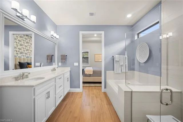 a spacious en suite bathroom with a double vanity sink and a mirror