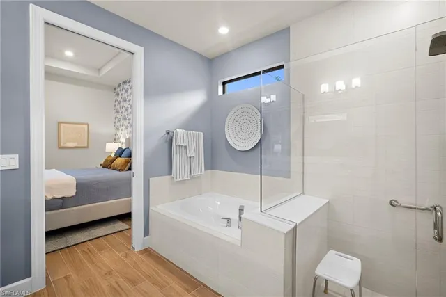 a bathroom with a tub a sink and a mirror