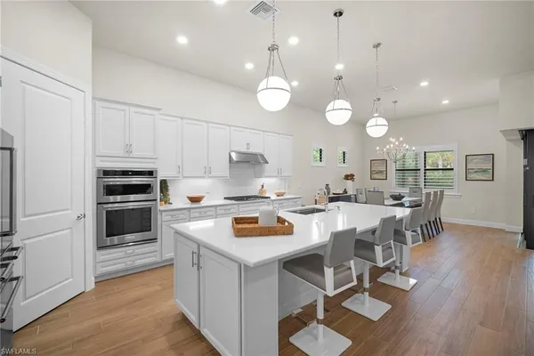 a kitchen with a stove cabinets and wooden floor