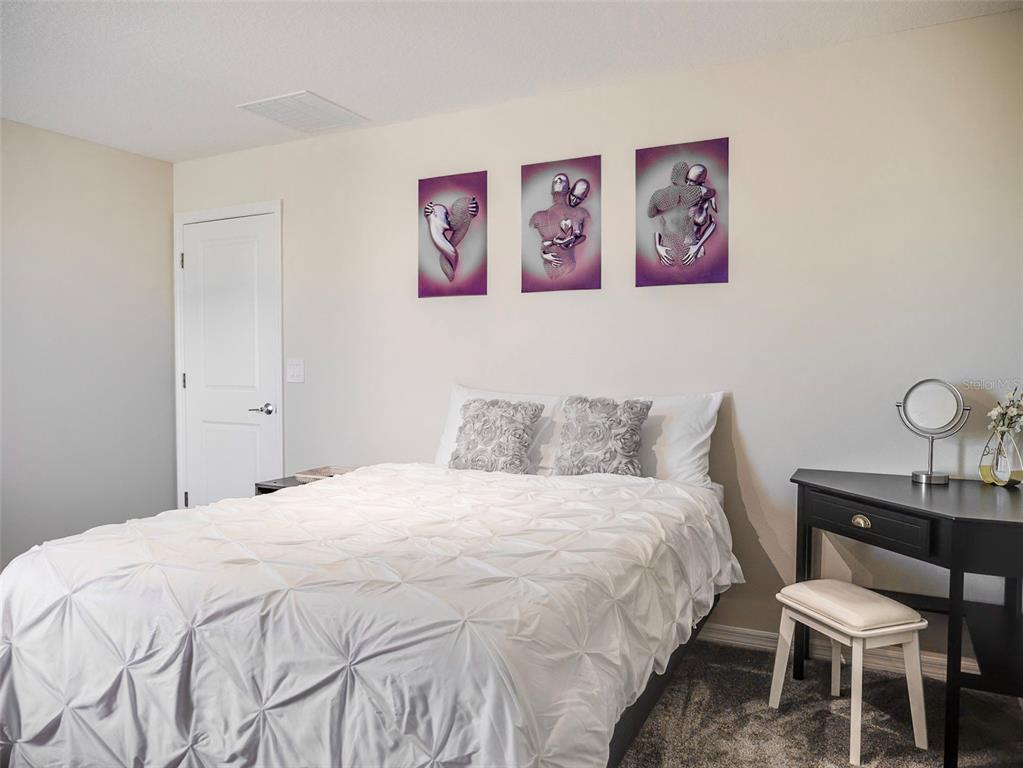 2949 Muller Oak Loop Ocoee, FL 34761 - Photo 19 of 36 a bedroom with a bed and a table in it