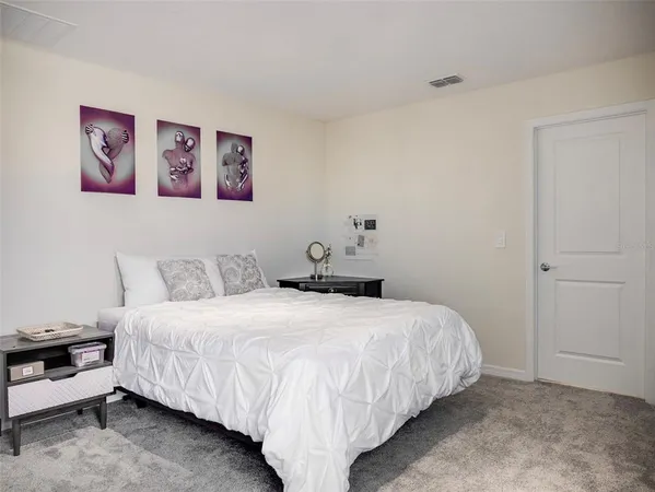 a bedroom with a bed and a wall painting
