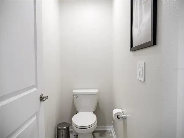 a white toilet sitting next to a white cabinet