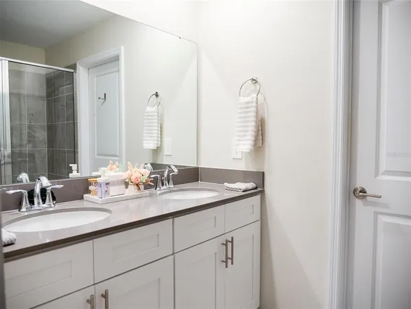 a bathroom with a double vanity sink and a mirror
