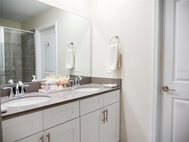 a bathroom with a double vanity sink and a mirror