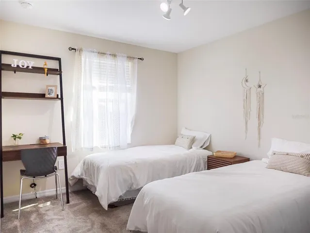 a bedroom with two beds and a chair