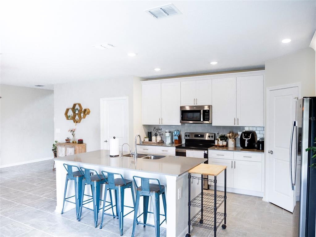 2949 Muller Oak Loop Ocoee, FL 34761 - Photo 8 of 36 a kitchen with a dining table chairs and microwave