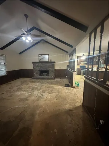 a view of an empty room with chandelier fan and a window