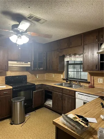 a kitchen with sink stove and cabinets