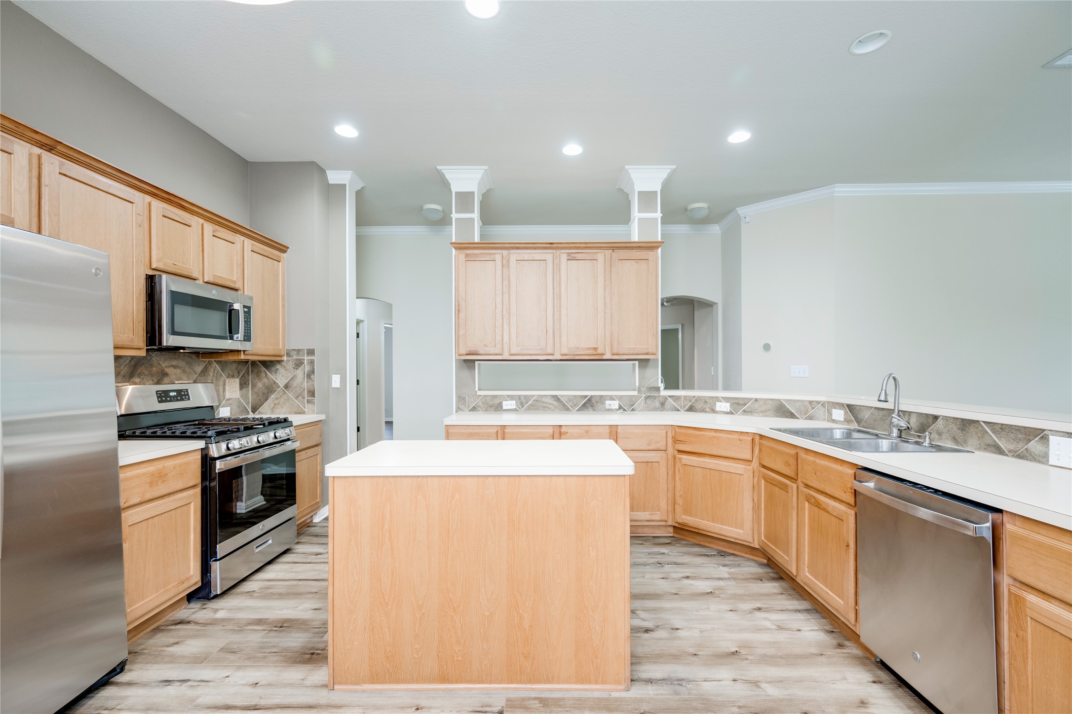 1813 Nelson Ranch Loop Cedar Park, TX 78613 - Photo 11 of 39 A well-lit kitchen featuring wood cabinetry, stainless steel appliances, and a central island.