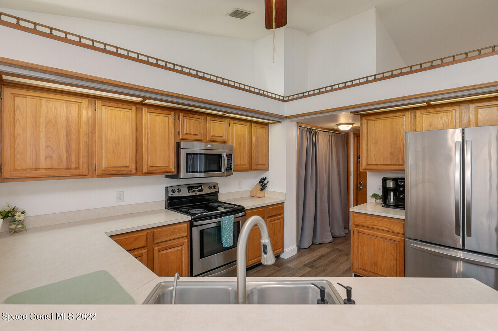 6385 Banks Avenue Cocoa, FL 32927 - Photo 38 of 47 a kitchen with stainless steel appliances granite countertop a refrigerator a stove and a sink with wooden floor