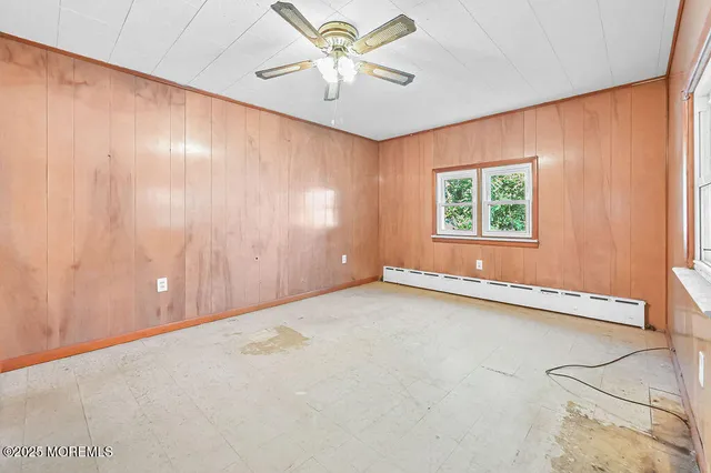 an empty room with windows and a ceiling fan