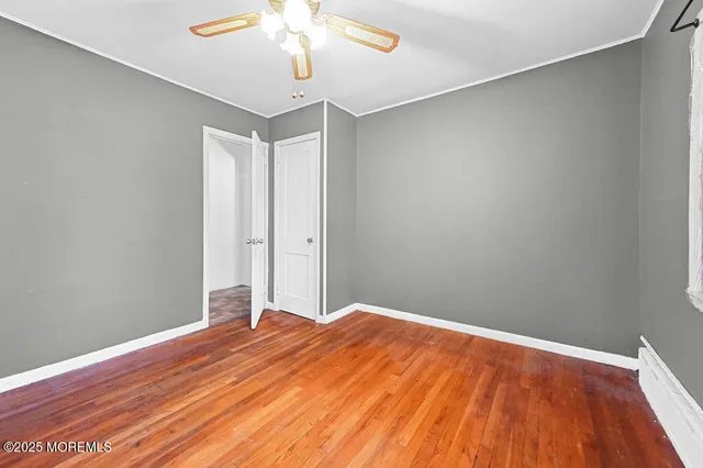 a view of a room with wooden floor and a ceiling fan