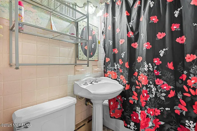 a bathroom with a toilet sink and mirror