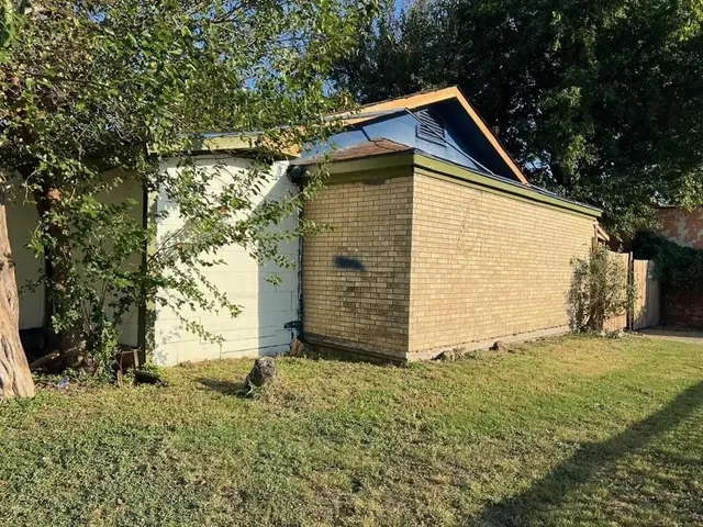 a view of backyard of house with wooden fence
