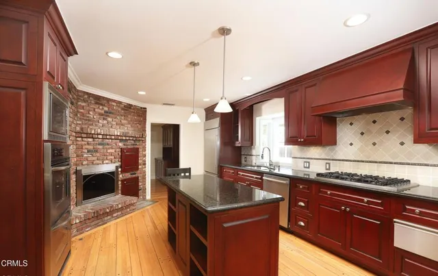 a kitchen with granite countertop a sink stove and refrigerator