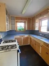 a kitchen with a stove a sink and a window