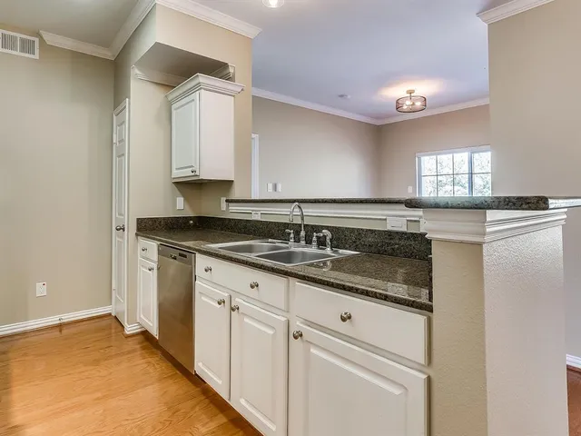 a kitchen with granite countertop white cabinets and a stove