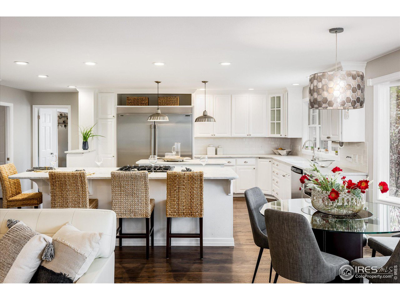 6919 Frying Pan Road Boulder, CO 80301 - Photo 9 of 36 a kitchen with stainless steel appliances kitchen island granite countertop a dining table chairs and white cabinets