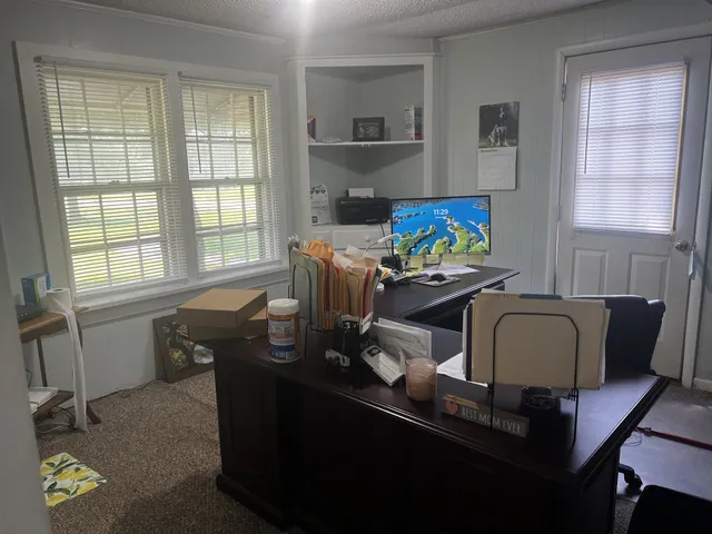 a view of a workspace with furniture and a window
