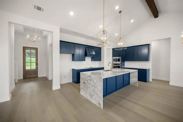 a view of a hallway with wooden floor and a chandelier