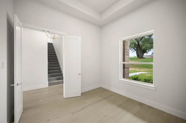 an empty room with windows and a ceiling fan