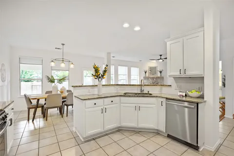 a kitchen with white cabinets stainless steel appliances and sink