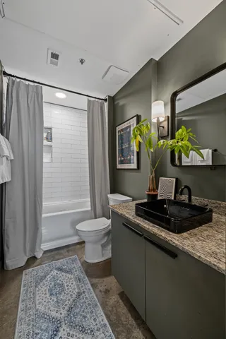 a bathroom with a granite countertop sink toilet and shower