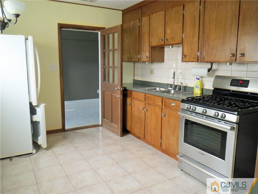 8 Sanders Road Edison, NJ 08817 - Photo 3 of 17 a kitchen with stainless steel appliances granite countertop a stove a refrigerator and a white cabinets