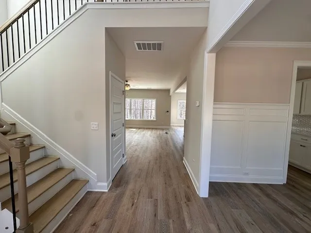 a view of a hallway with wooden floor and staircase