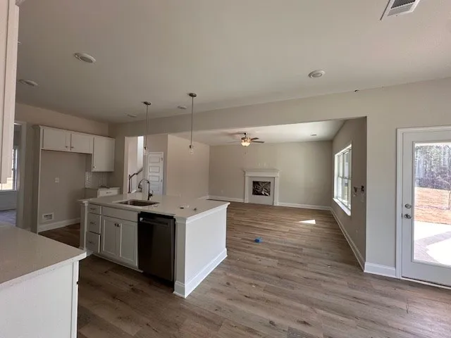 a kitchen with cabinets and wooden floor