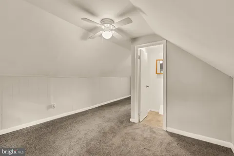 an empty room with a chandelier fan and closet area