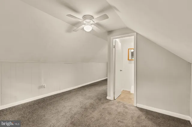 an empty room with a chandelier fan and closet area