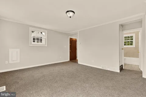 a view of an empty room with closet and a window