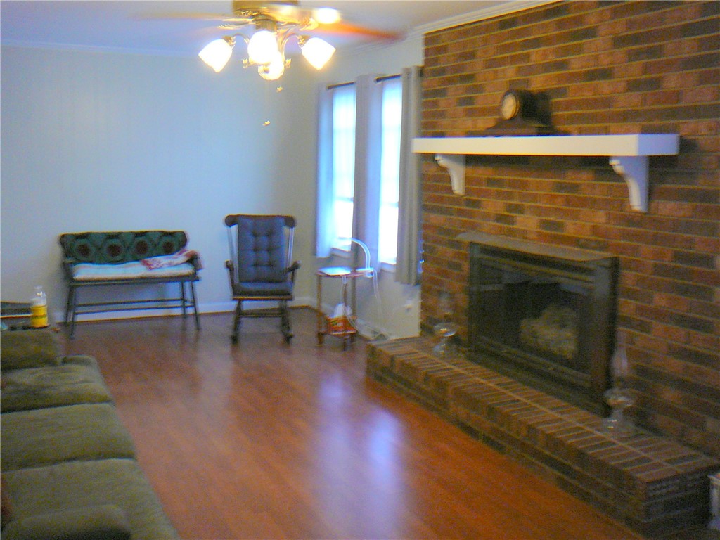 37 Camelia Circle Williamston, SC 29697 - Photo 11 of 25 This inviting living area features warm wood flooring and a classic brick fireplace.