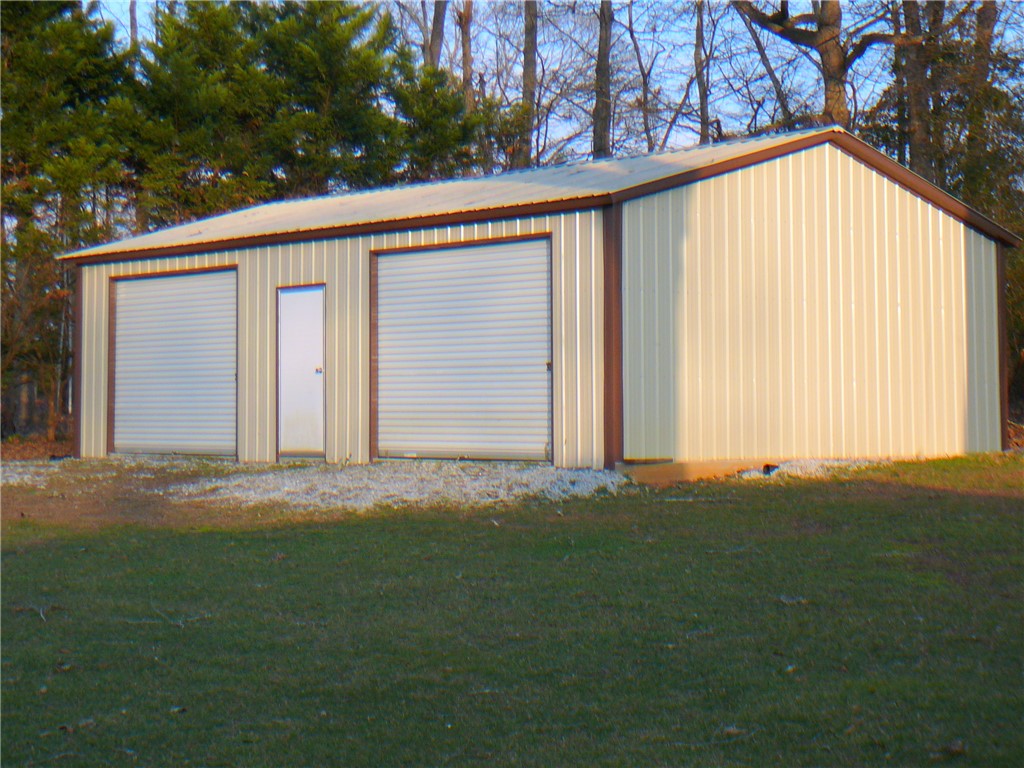 37 Camelia Circle Williamston, SC 29697 - Photo 22 of 25 This metal building offers convenient storage and utility space amidst a natural setting.