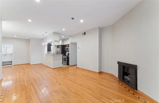 a view of empty room with wooden floor