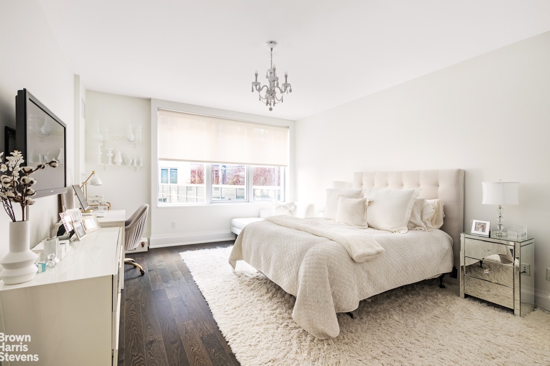 50 Riverside Boulevard, Unit 3H Manhattan, NY 10069 - Photo 6 of 21 a bedroom with a bed a large window and wooden floor