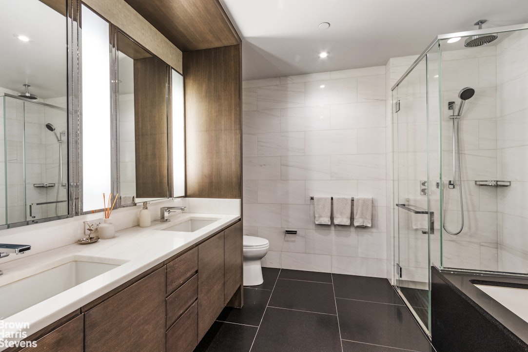 50 Riverside Boulevard, Unit 3H Manhattan, NY 10069 - Photo 7 of 21 a bathroom with a double vanity sink toilet and shower