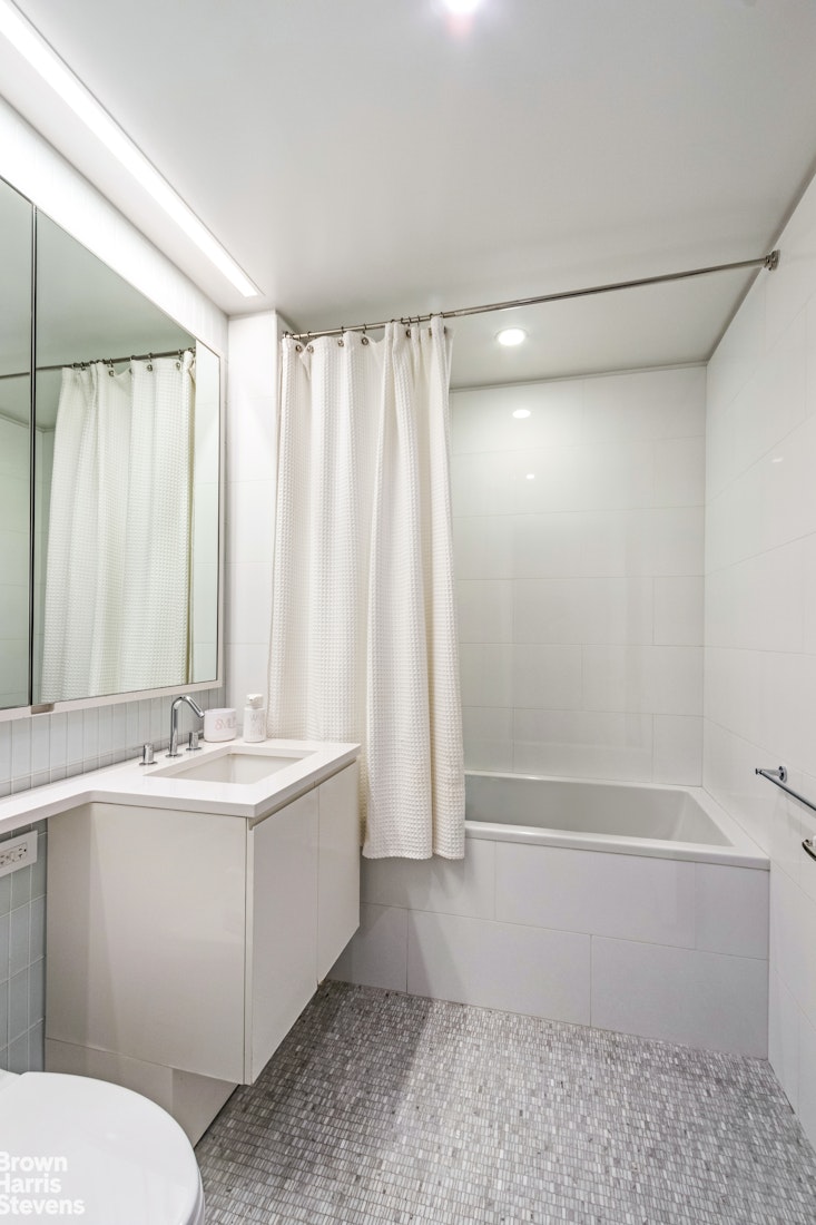 50 Riverside Boulevard, Unit 3H Manhattan, NY 10069 - Photo 9 of 21 a bathroom with a double vanity sink a toilet and a shower