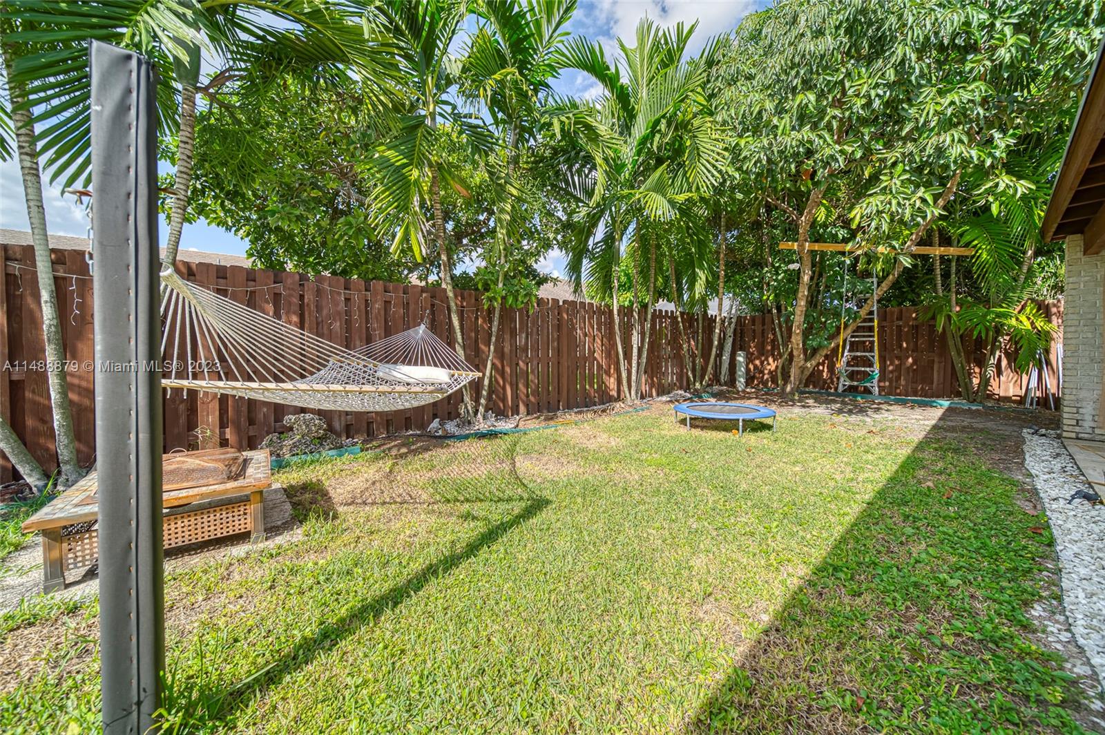 9904 Southwest 133rd Court Miami, FL 33186 - Photo 31 of 43 a view of a patio with table and chairs and wooden fence