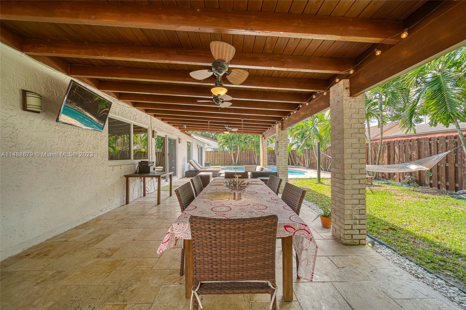 9904 Southwest 133rd Court Miami, FL 33186 - Photo 33 of 43 a view of a patio with table and chairs potted plants with floor to ceiling window